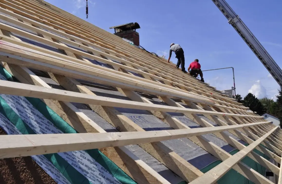 Two workers working on a roof.