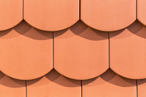 A close-up of a red-orange clay shingle roof.
