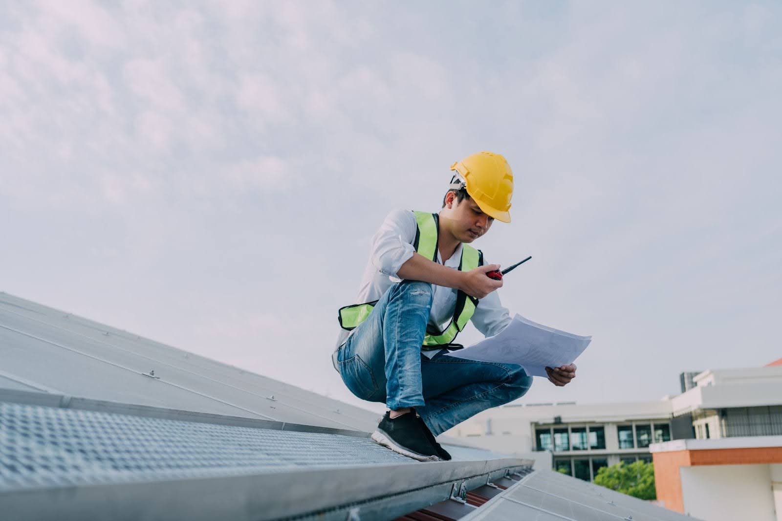 A service engineer reviewing plans communicates the issues via radio during inspection.