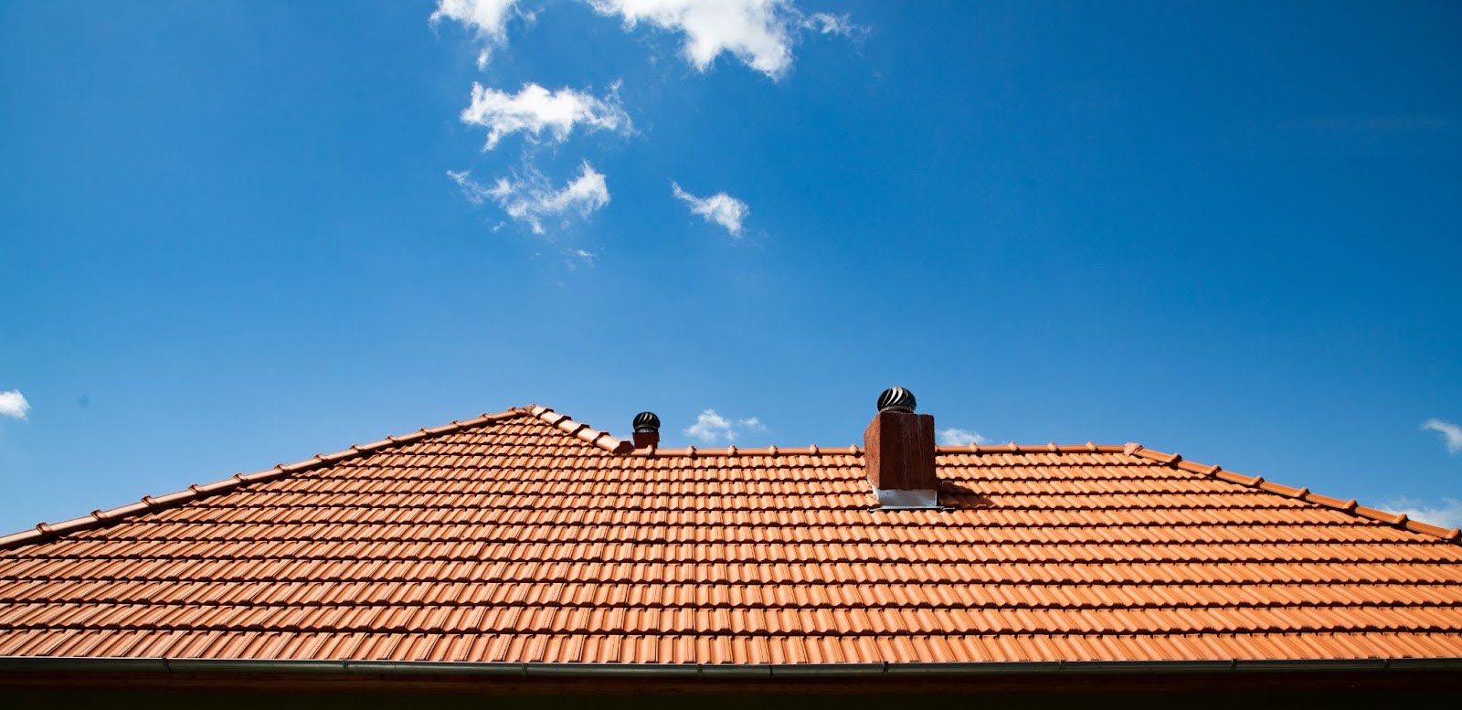 A home with a fresh install of new red roofing tiles.