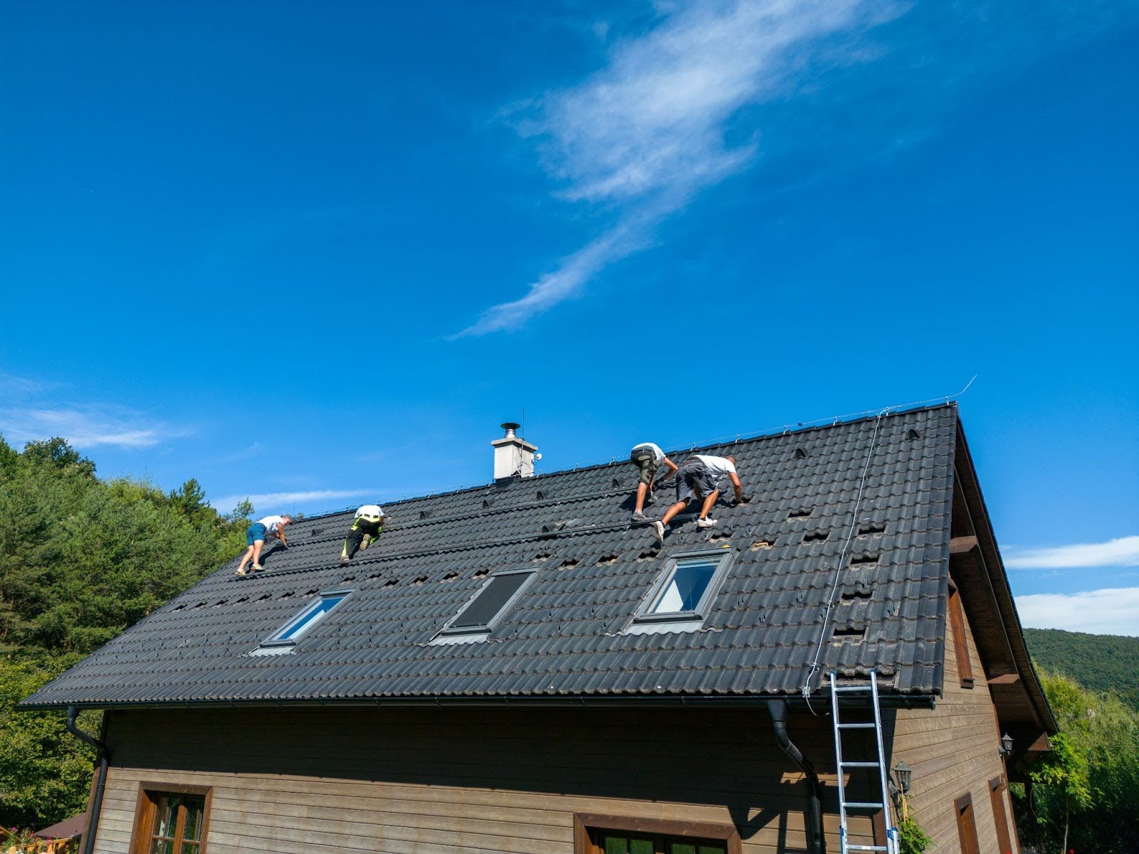 A team of workers install a new photovoltaic solar system on a roof.